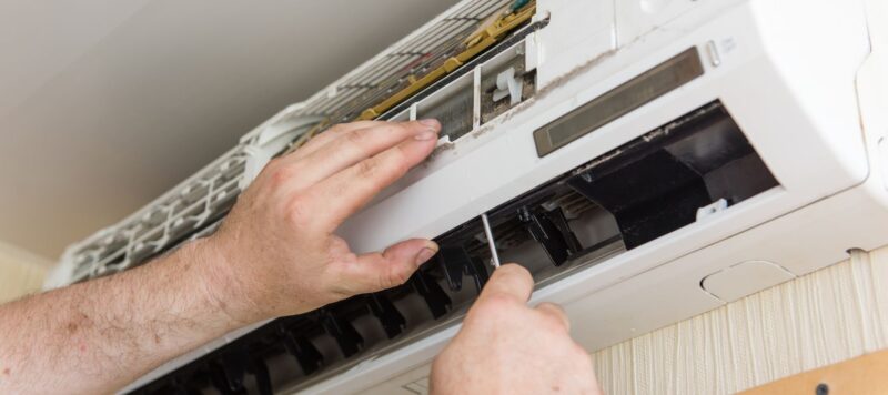technician using a screwdriver during a ductless ac repair